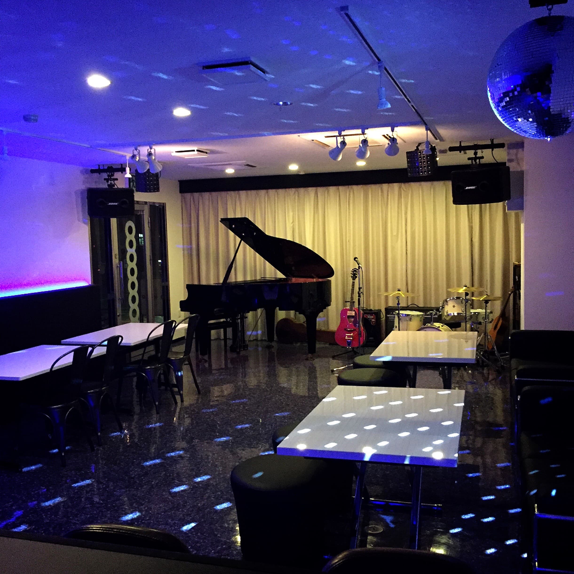 グランドピアノ・ドラム・ミラーボールのある店内